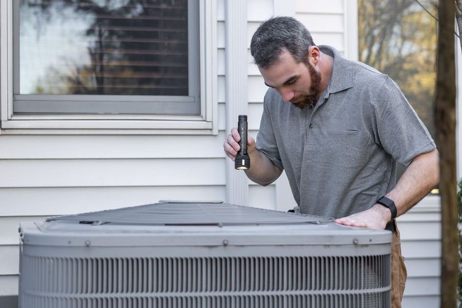 Technician servicing a home AC unit