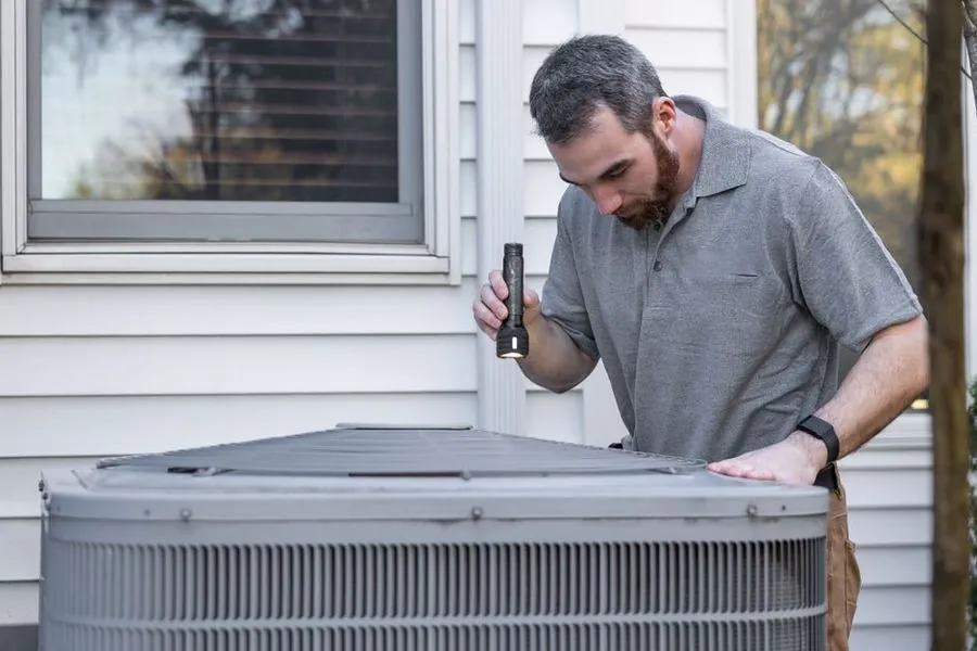 Technician servicing a home AC unit