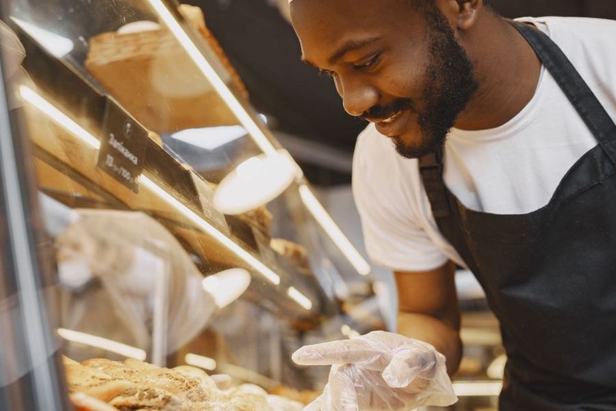 Baker arranging fresh pastries at the counter