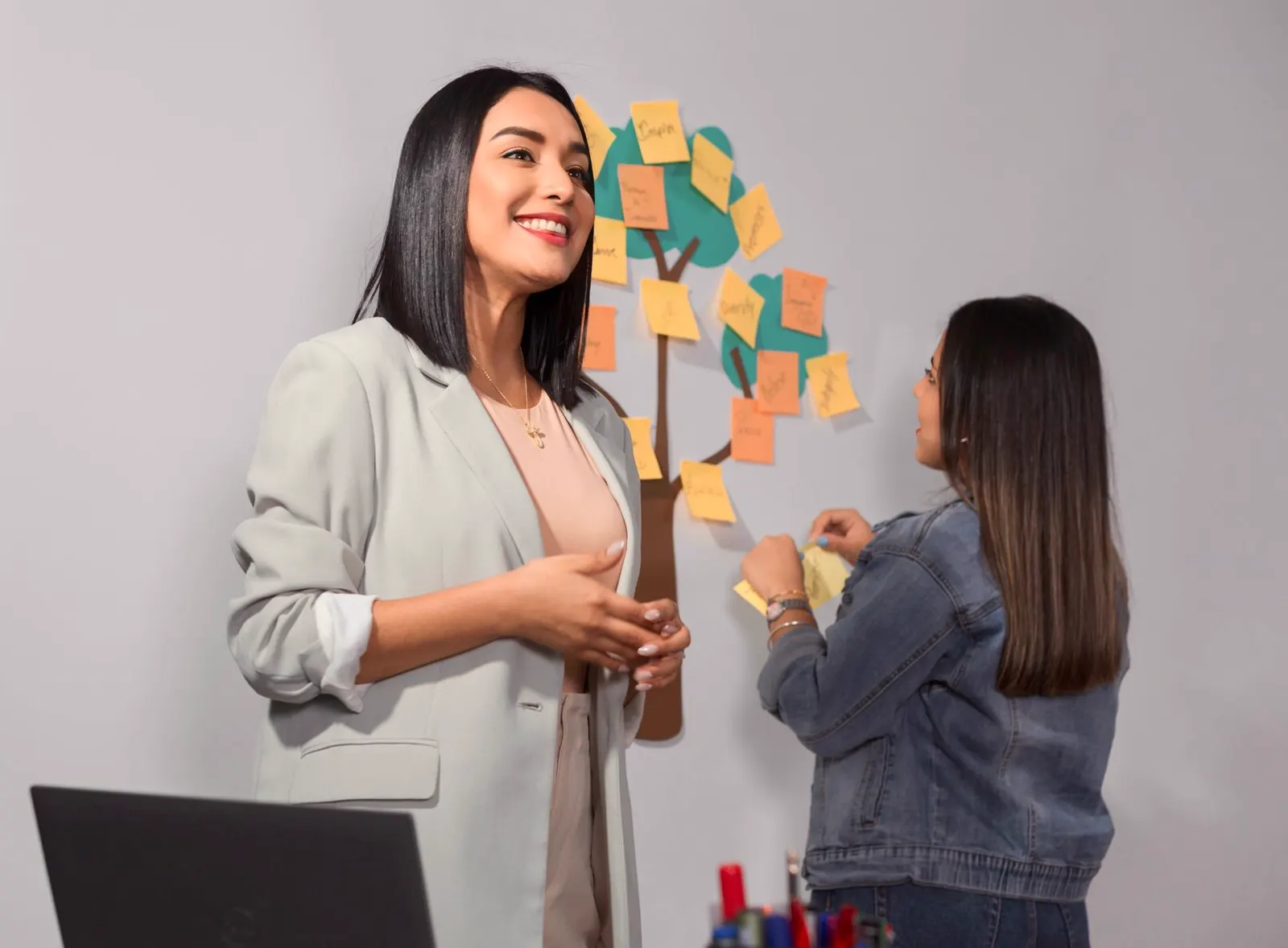 Una consultora explica un plan de trabajo junto a una pizarra con notas