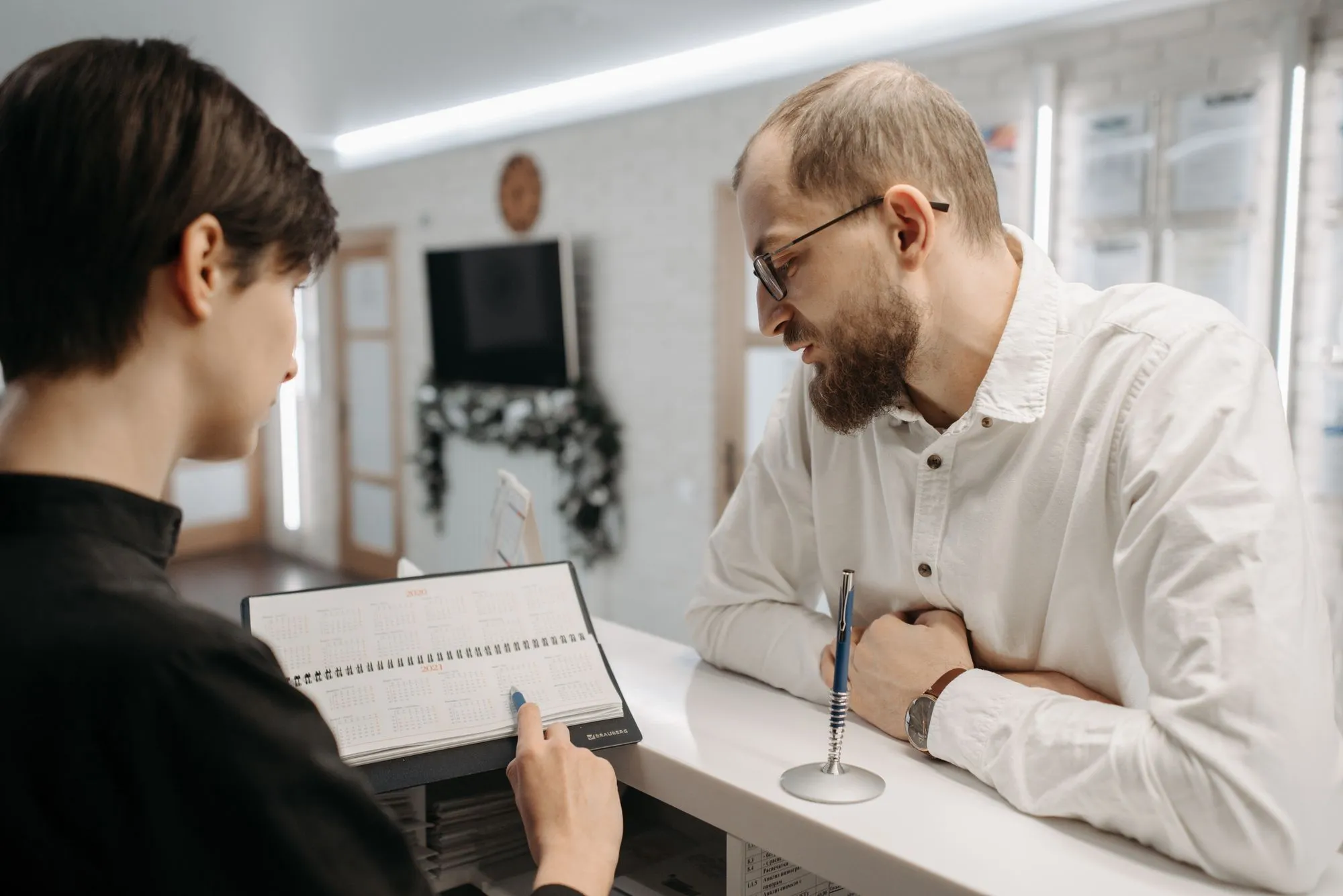 Una recepcionista revisa la agenda de citas con un cliente
