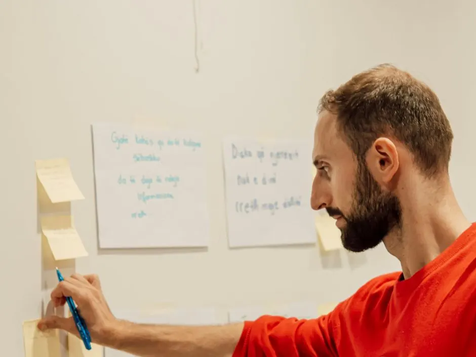 A person placing sticky notes on a wall during a planning session